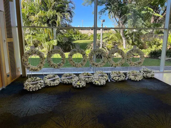 Some wreaths on stands or easels and some wreaths laying down