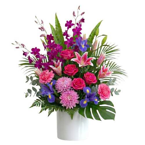 Executive - pink, blue and purple flower arrangement in a white ceramic pot