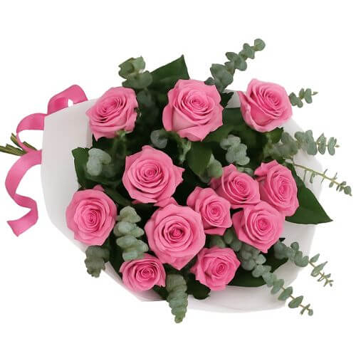 Bouquet of pink roses with greenery and a pink ribbon on a white background